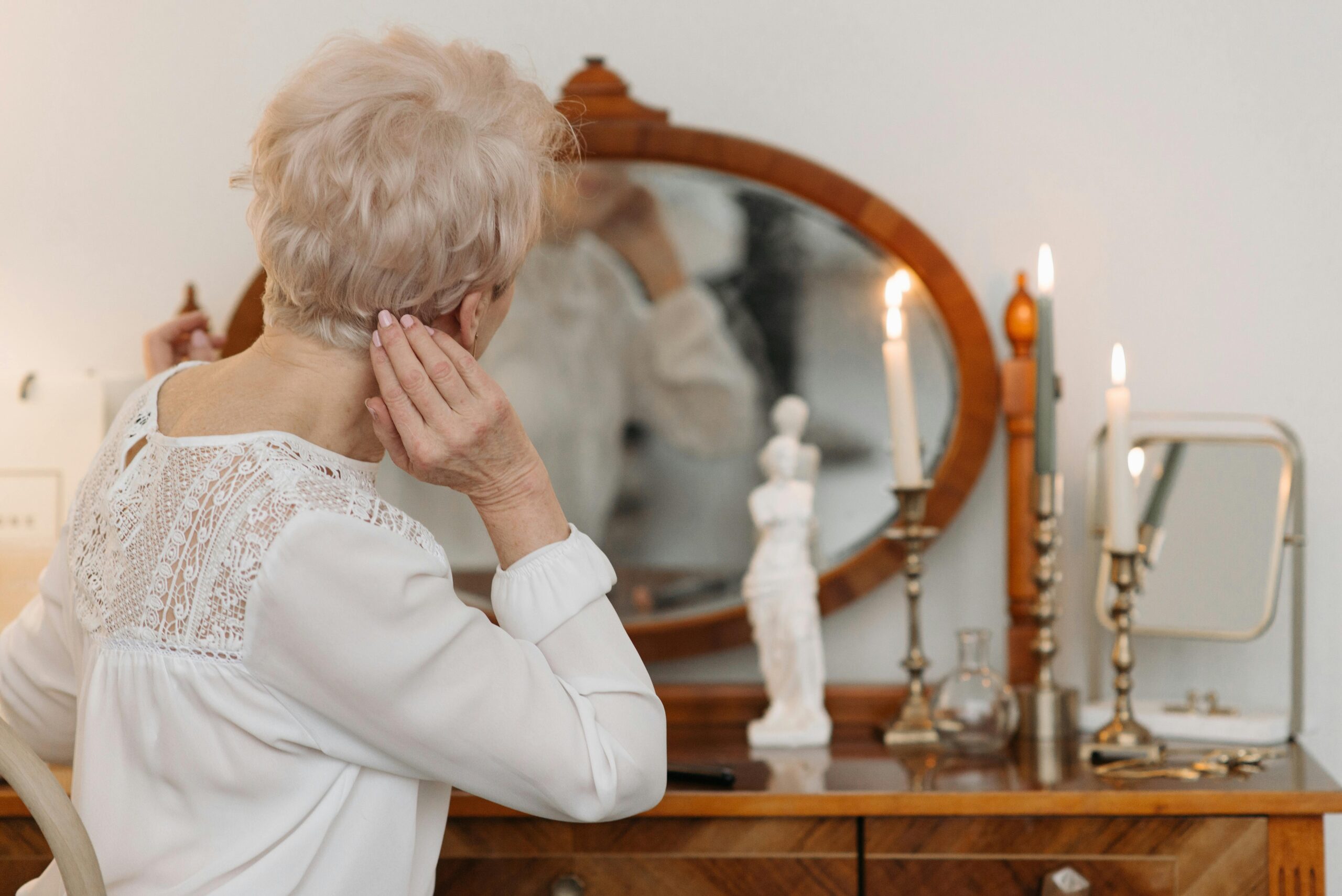 Kostenloses Stock Foto zu &auml;ltere frau, anz&uuml;nden von kerzen, eitelkeit